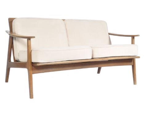 A stunning retro vintage teak wood framed two seater sofa / couch .The sofa having angular frames with shaped armrests and a 