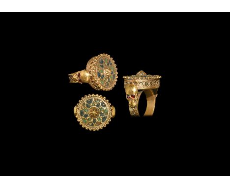 18th-19th century AD. A gilt metal flat-section hoop with running knotwork band, each shoulder a skull with faceted glass eye