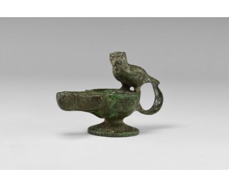 An undated archaistic bronze oil lamp with wide conical base, raised collar to the spout, volute scrolls to the nozzle, sitti
