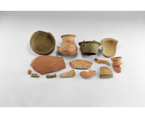 1st-3rd century AD. A mixed group of unglazed ceramic fragments including an oil lamp nozzle, discoid oil lamp, moulded human