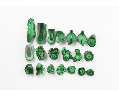 A group of twenty sawn and polished pieces of malachite stalactites, cut in various directions to reveal inner layering in va