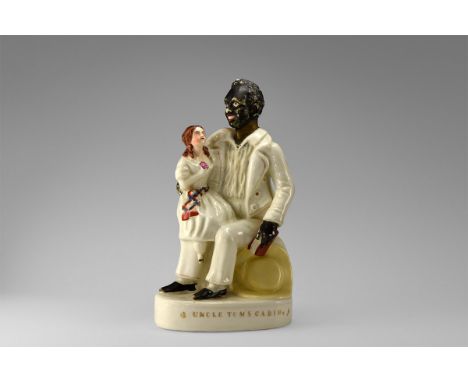 19th century AD. A Staffordshire cast and glazed ceramic figure depicting Uncle Tom seated, holding a book, with Little Eva u