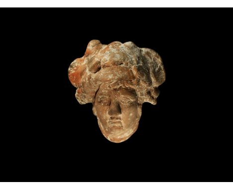 An undated archaistic ceramic plaque of the head with masses of curly hair and vine and grape wreath.  325 grams, 13.5cm (5 1
