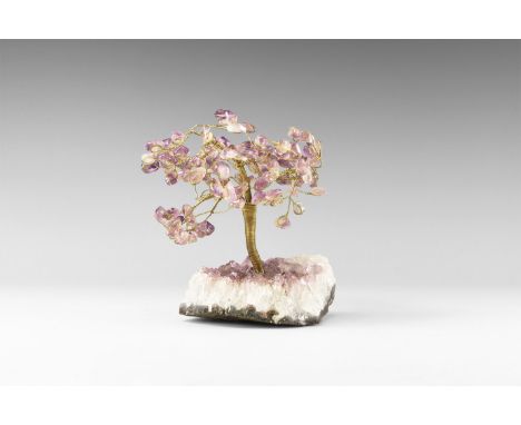 A large size gemstone tree consisting of a brass trunk and branches tipped with polished amethysts, mounted on a section of a