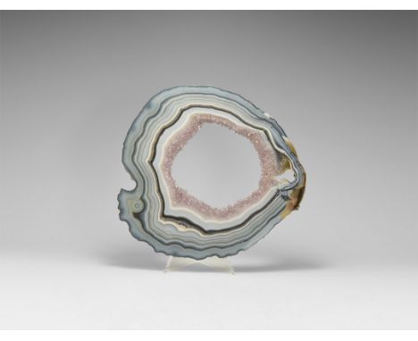 A polished slice of natural banded agate in blues and lavenders, hollow centre filled with lilac amethyst crystals, polished 