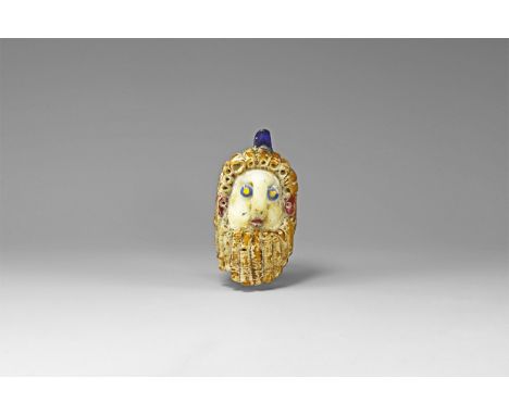 20th century AD. A hollow-formed glass head pendant with applied hair, beard, eyes and mouth, loop to the brow.  88 grams, 78