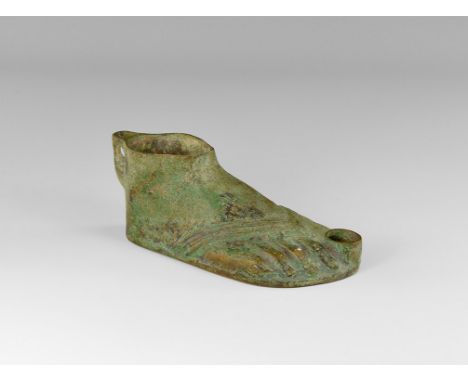An undated archaistic bronze oil lamp, in the form of a foot, loop at the back for lid; open at the ankle for oil; sandal str