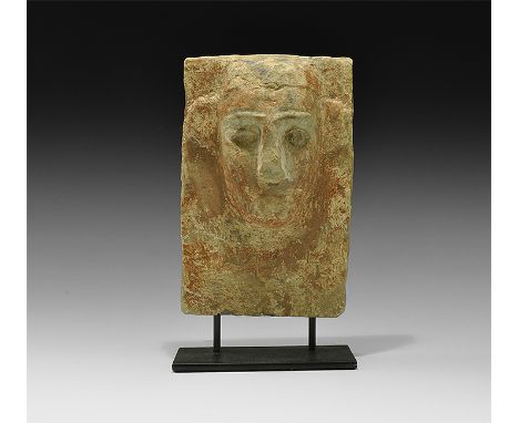 2nd century BC-2nd century AD. The top of a rectangular alabaster stele with stylised human face carved in the half-round wit