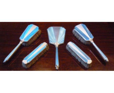 AN ART DECO SILVER AND ENAMELLED FOUR PIECE TOILET SET COMPRISING A HAND MIRROR, HAIR BRUSH AND TWO CLOTHES BRUSHES AND A SIM