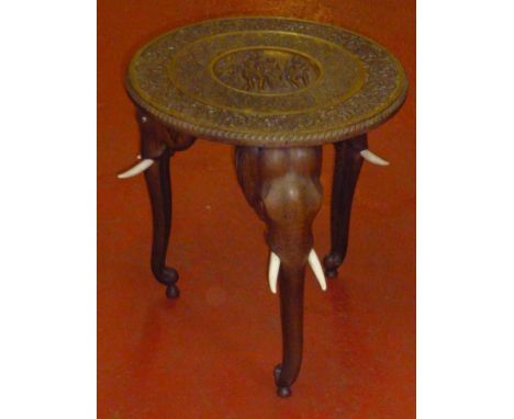 ORNATELY CARVED TABLE ON THREE INDIAN ELEPHANT HEAD AND TRUNK LEGS (h: 54.5 cm dia: 51 cm)