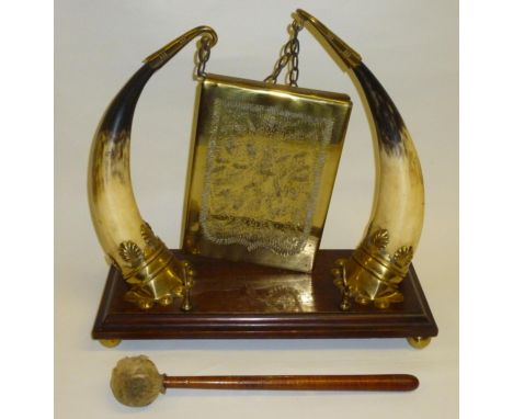 RECTANGULAR BRASS GONG SUSPENDED FROM BRASS HOOKS ATTACHED TO THE TIPS OF HORNS ON A WOODEN STAND SUPPORTED BY SCALLOP SHELL 