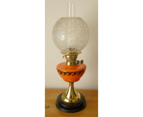 BRASS OIL LAMP WITH ORANGE GLASS RESERVOIR WITH BLACK PAINTED CLASSICAL WAVE DECORATION WITH ETCHED BOWL STYLISED LEAF DESIGN