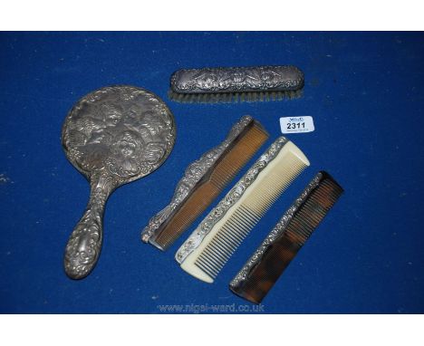 A matching Silver backed hand mirror, brush and comb, one other silver backed comb and a plated comb