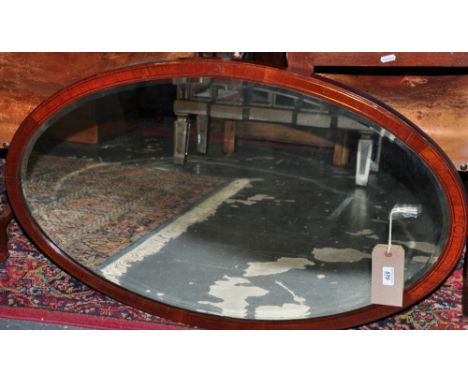 An Edwardian oval bevelled wall mirror