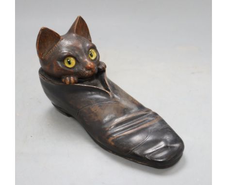 An early 20th century carved wood 'cat in a shoe' inkwell, with hidden compartments, length 20cm