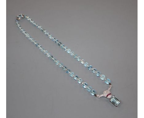 A mid to late 20th century white metal, aquamarine, ruby and diamond set drop pendant, on an aquamarine bead necklace with aq