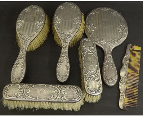 Silver six piece dressing set, to include four brushes, comb and mirror, all embossed with scrolling foliage, maker Henry Cha