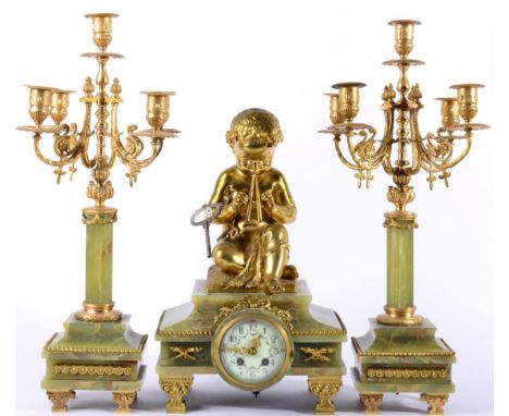 A Green Onyx and Gilt Metal Mounted Striking Mantel Clock with Garniture, circa 1900, surmounted by a seated boy piper, gilt 