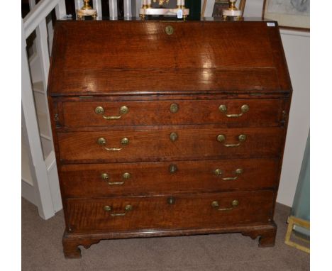 A George III Oak Bureau, late 18th century, the fall enclosing a fitted interior of pigeon holes, small drawers and a cupboar