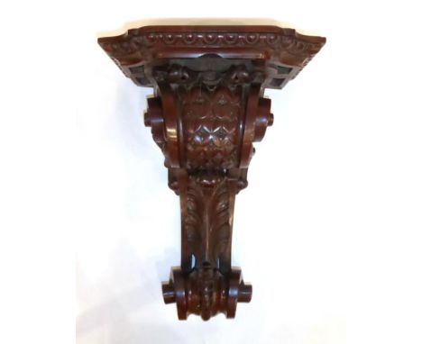 A Victorian Mahogany Carved Wall Clock Bracket, late 19th century, scroll and leaf decorated carved support, 35cm by 46cm