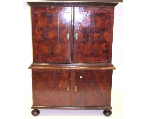 A Walnut and Featherbanded Cupboard, the bold cornice above two cupboard doors with moulded base, two further cupboard doors 