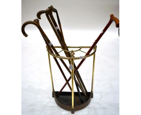 A Brass Stick Stand, late 19th century, of demi-lune form with baluster finials, 63cm high, with five various walking sticks 