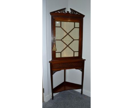 An Edwardian Mahogany Free-Standing Corner Cupboard, early 20th century, the fret carved architectural pediment above an astr