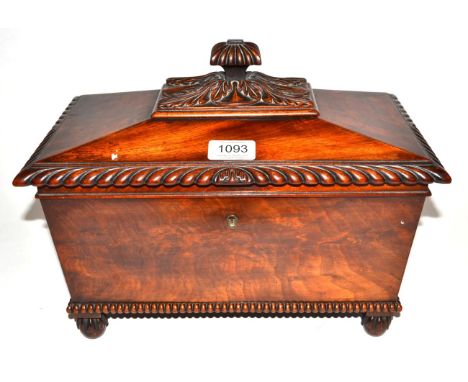 A George IV Mahogany Tea Caddy, of sarcophagus form with gadroon and leaf handle and borders, enclosing a central well with g