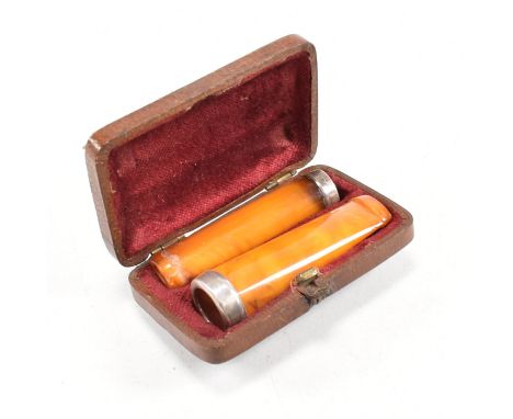 An Edward VII cased pair of butterscotch Amber cheroot holders with hallmarked silver mounted collars. Hallmarked for Glasgow