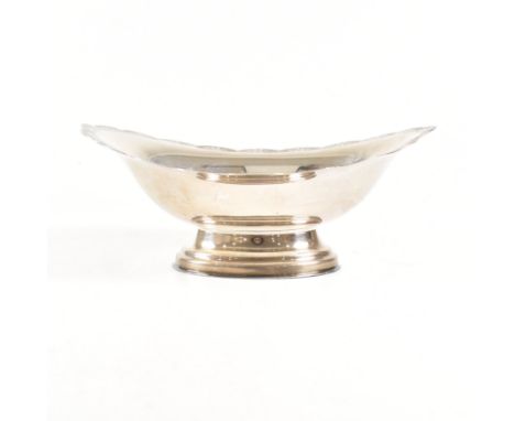 A mid century hallmarked silver bon bon dish. The dish of oval form having a petalled rim with engine turned foliate pattern.