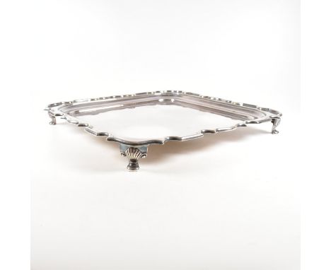 A Walker & Hall silver plated salver. The tray sitting on four hoof feet rising to square form with serpentine border. Marked