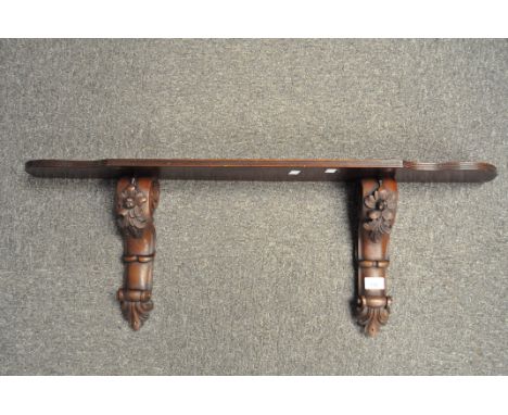 A 20th century rosewood wall shelf, the supports carved with flowers and foliage, width 90cm