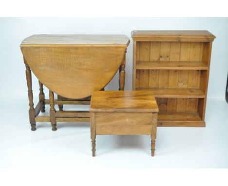 An oak oval gate leg table, 76.5cm x 91cm x 136cm; a pine bookcase with two shelves, 82.5cm x 69cm x 23cm; and a sewing box w