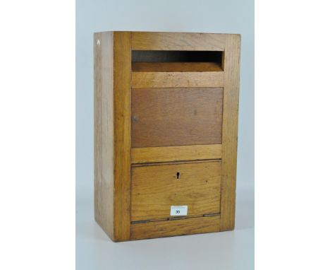 A vintage 20th century golden oak letter box with military notation to reverse, height 43cm
