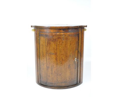 A 19th century oak bow fronted corner cupboard with one curved shelf, lock with key, height 69cm