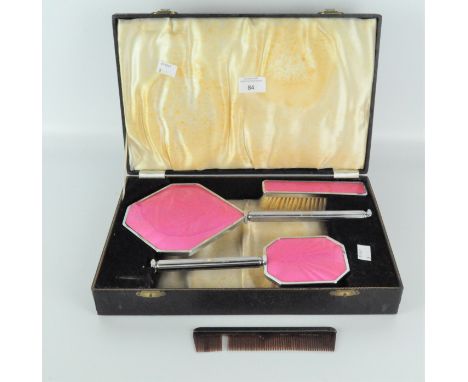 An Art Deco dressing table set, comprising two brushes, a comb and mirror, all mounted in silver plate with turned enamel eff