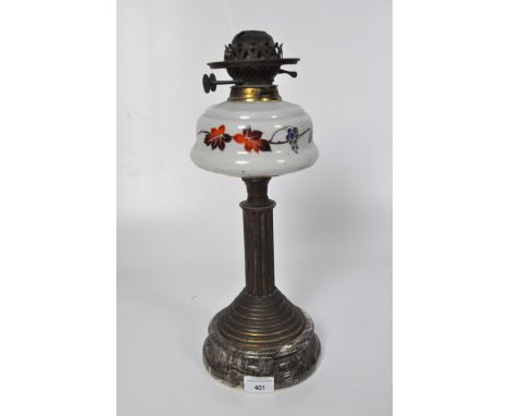 A Victorian oil lamp, glass reservoir painted with vines, supported by a gilt column stand, on a circular stone base, height 