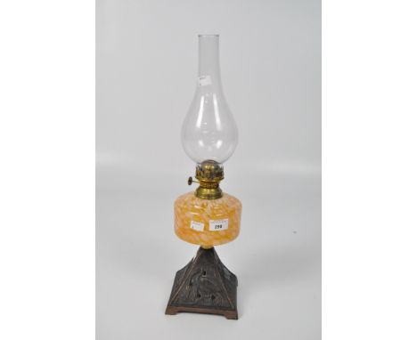 A 20th century oil lamp, the metal base with pierced decoration of birds, with a orange and white glass reservoir, height (in