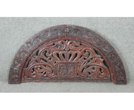 A 20th century carved and pierced Oriental semi circular panel with stylised foliate and floral design. H.48 W.92 D.4cm 