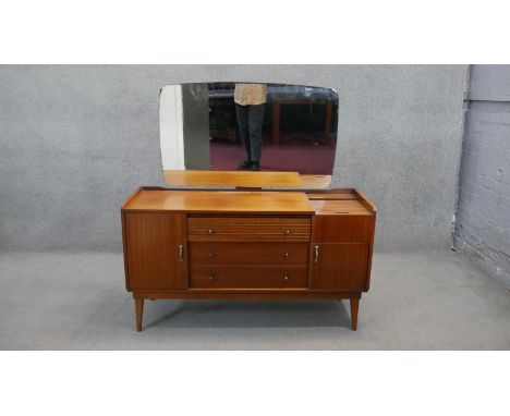 A vintage teak Austinsuite dressing table with tambour shutter revealing fitted well section raised on shaped tapering suppor