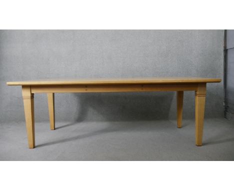 A contemporary light oak dining table on square tapering supports. H.76 W.218 D.99cm 