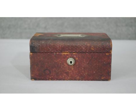 A vintage red leather effect lockable travelling jewellery casket with blue velvet interior and two removable partitioned tra