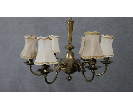 An early 20th century gilt brass six branch chandelier with cream silk shades. Swag detailing to the branches.  H.45 W.54cm 