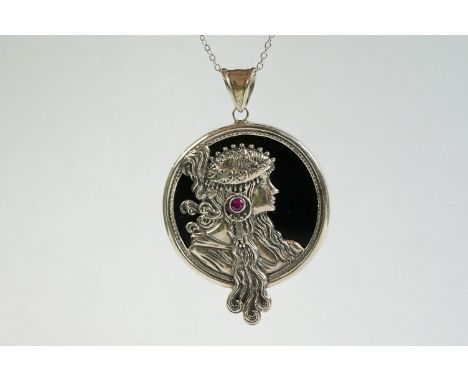 A silver and onyx pendant necklace in the form of a lady with a cabouchon ruby 