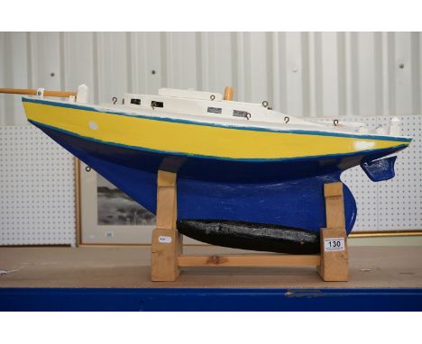 Scratch-built painted wooden model of a yacht, in blue, yellow and white, with decking and hatch details, approx 90cm long 