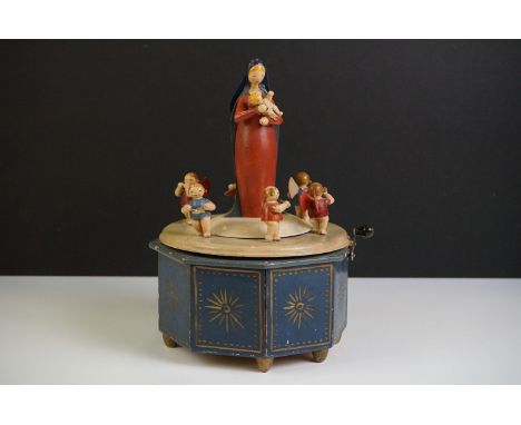 A German painted wooden musical carousel of octagonal form surmounted by Mary holding the baby Jesus, surrounded by six angel