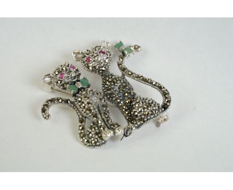 A silver and marcasite cat brooch set with ruby eyes and emerald bow tie