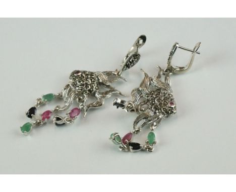 A pair of silver angle fish earrings set with marcasites, ruby, sapphire and emeralds 