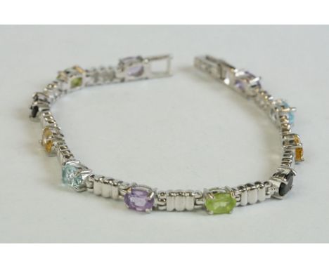 A silver bracelet set with amethyst, peridot, ruby, aquamarine etc 