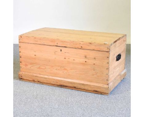 An antique pine trunk, with a domed hinged lid, flanked by carrying handles92w x 53d x 47h cm